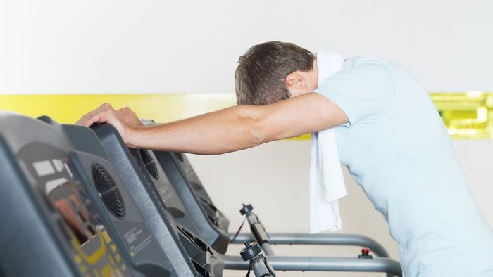 a man standing near a treadmill
