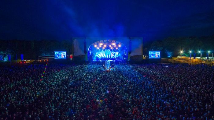 A nighttime crowd enjoying a live band performance at a summer music festival