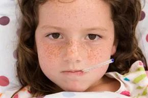 a young girl feeling unwell with a thermometer