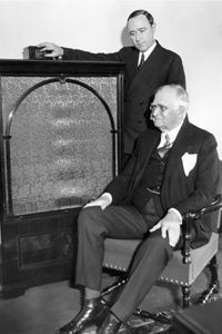 Merlin H. Aylesworth, the President of NBC, stood while Paul D. Cravath, the President of the Metropolitan Opera Company, sat as they tuned into the opera on the radio. This followed their opening statements on Christmas Day in 1931.