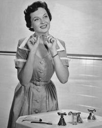 A 1950s woman gazes wistfully at a strand of dental floss, lost in thought.
