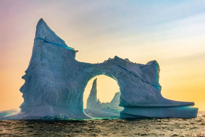 A stunning sky highlights two uniquely shaped icebergs in Greenland’s Scoresby Sound.