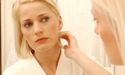 A woman gazes into a mirror