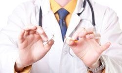 A doctor snapping a cigarette in half
