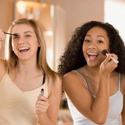 two women applying makeup