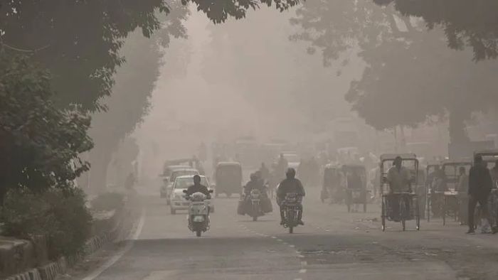 A thick haze from air pollution obscures a road in Delhi, India.