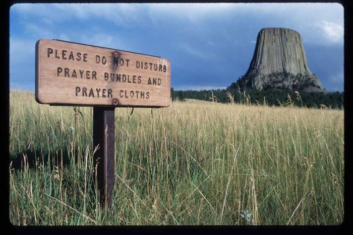 A wooden sign positioned near Devils Tower.