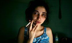 A girl smoking a cigarette in a dimly lit room