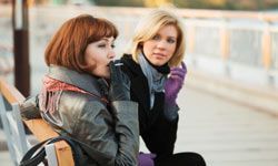 two girls chatting on a bench