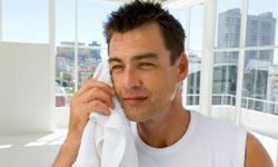 A man using a towel to wipe his face