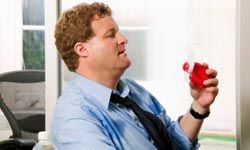 A businessman holding a handheld fan