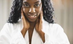 black woman touching her face