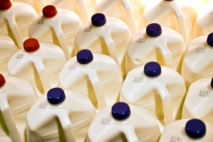 A top-down view of milk gallons featuring blue and red caps.