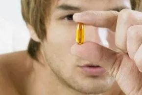 A man examines a pill