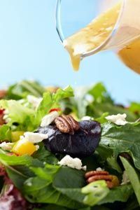 drizzling dressing over salad