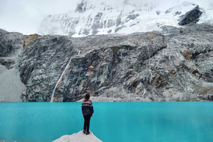 A woman gazes at a glacial lake in Huascarán National Park.
