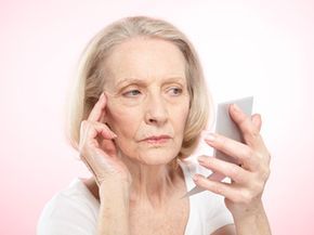 A mature woman examining her reflection in the mirror