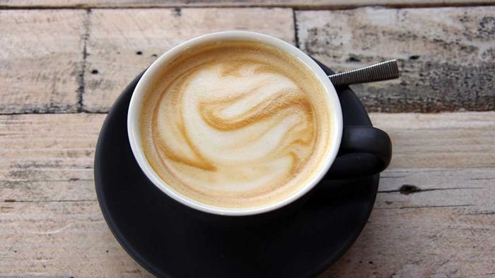 A flat white coffee is shown in the image