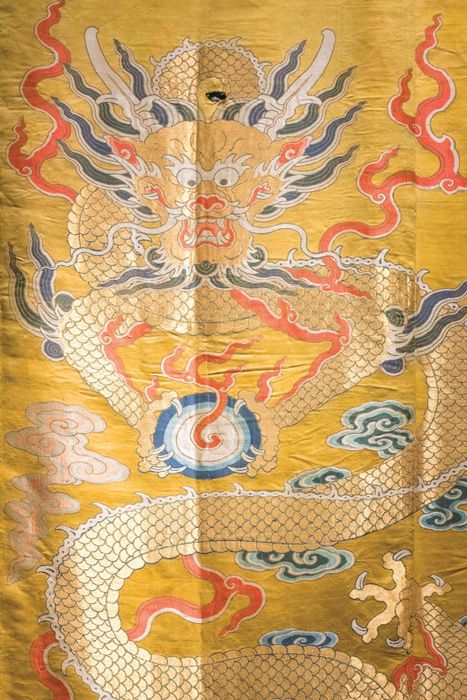 A silk panel featuring a dragon adorned with finely ground imperial yellow dye.