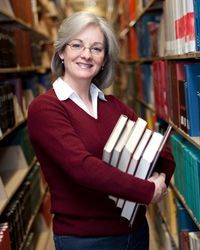 woman surrounded by books in a library