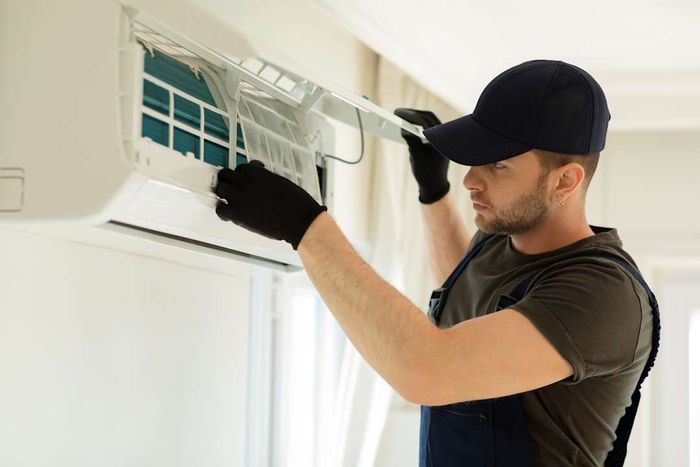 A man installing and cleaning an air conditioner.