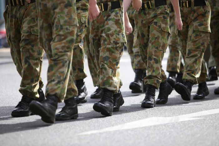 A line of service members marching in cargo pants.