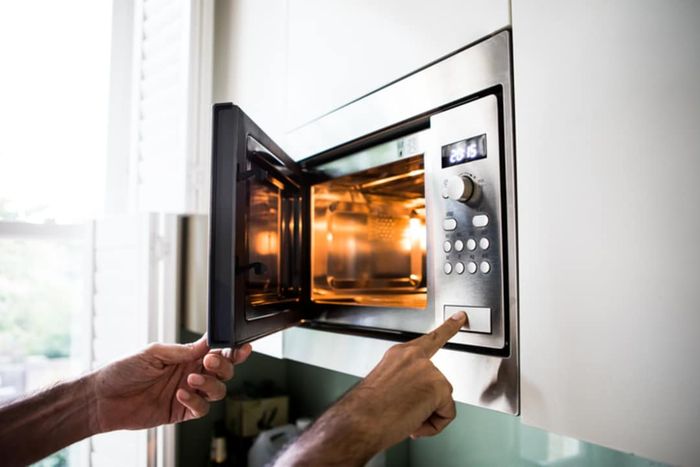 A man operating a microwave oven.