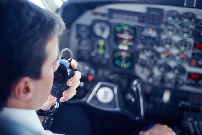 Pilot in the cockpit communicating via radio