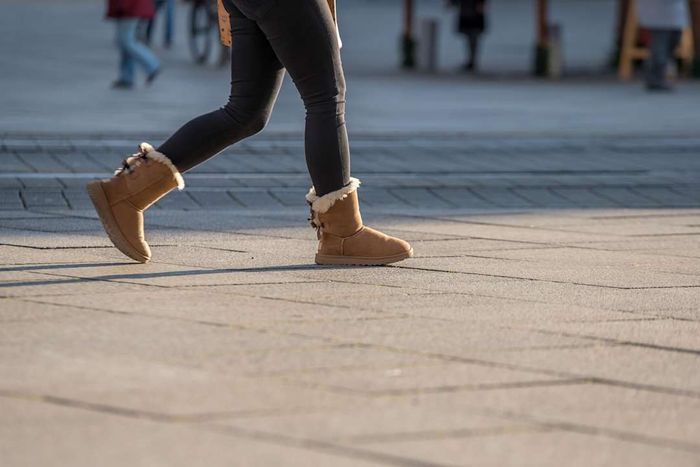 A person strolling down the street wearing UGG boots.