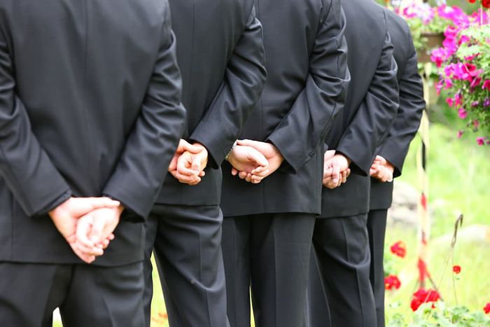 A photo of groomsmen standing in a line