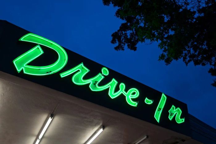 Neon sign reading 'drive-in' at night