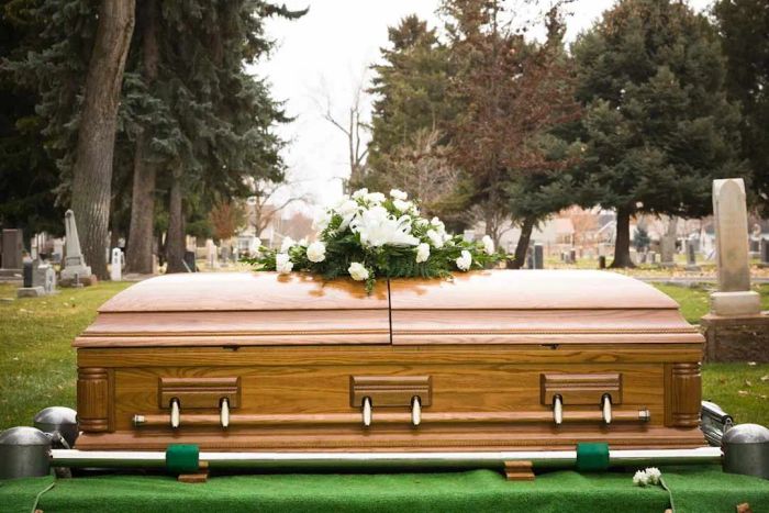 A coffin ready to be lowered six feet into the ground.