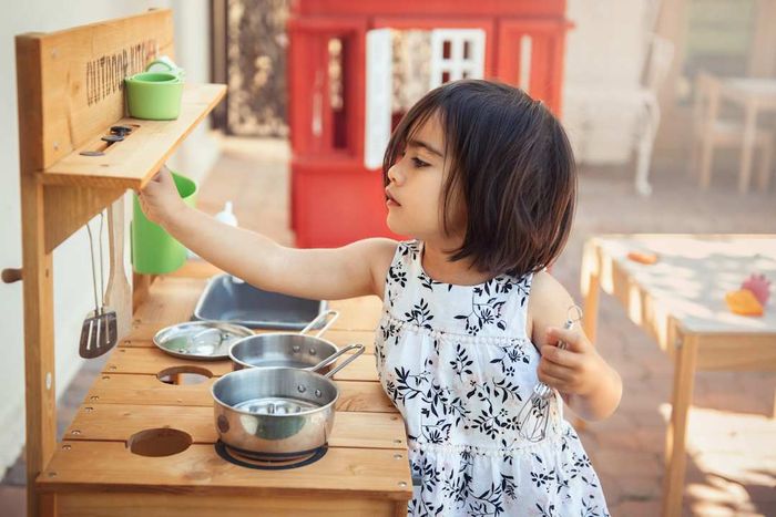A young girl enjoying a pretend cooking session