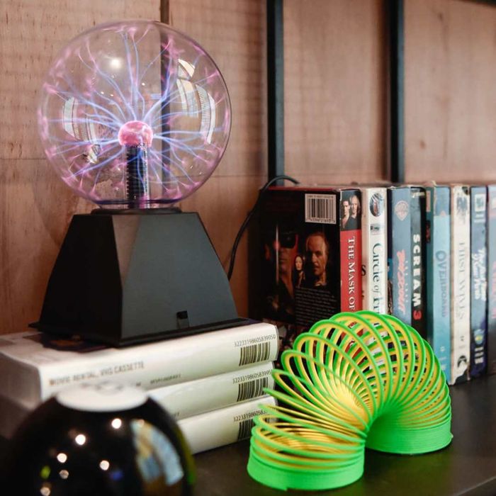 A Slinky, Magic 8 Ball, and Plasma Ball showcased on a shelf