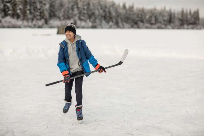 A boy skating on ice with a hockey stick
