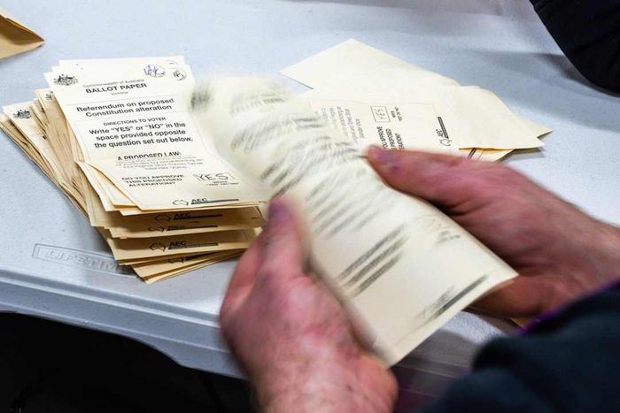 An individual handling and tallying election ballots in Australia.