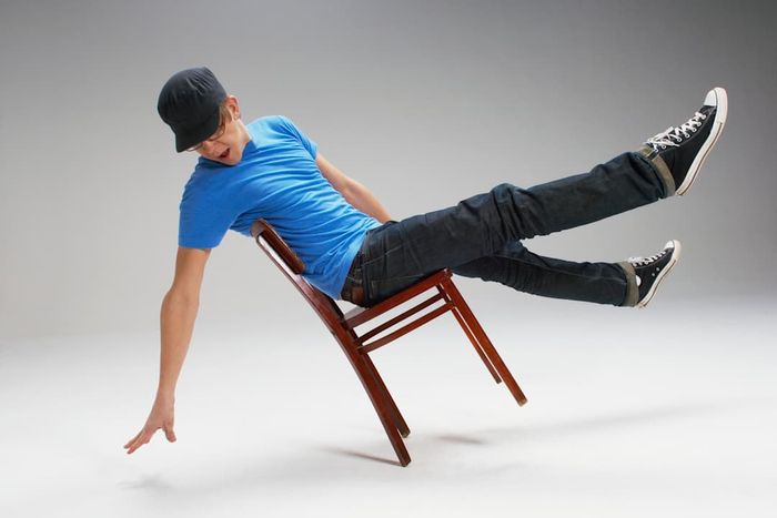 A man balancing on a chair