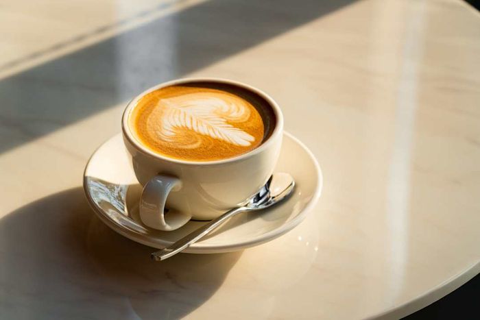 photo of a latte bathed in sunlight on a cafe table
