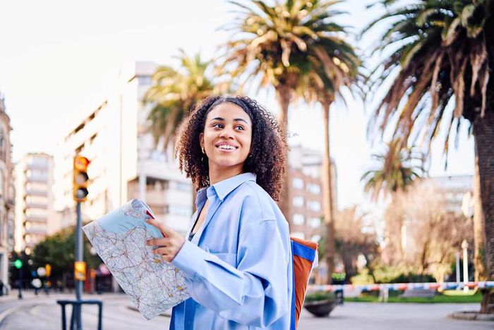 photo of a woman holding a map while exploring the city