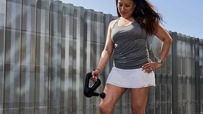Leading massage guns: A woman using a Therabody Theragun Prime massage gun.
