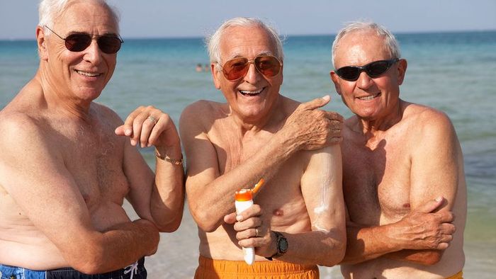 elderly men applying sunscreen
