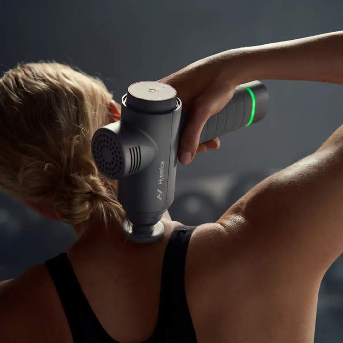 Top massage guns: A woman using the Hypervolt 2 on her neck.