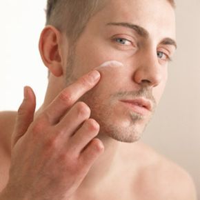 A man applying moisturizer to his face.