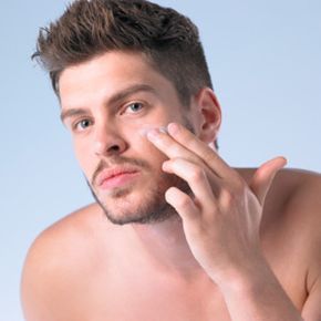 A man applying moisturizer to his face.