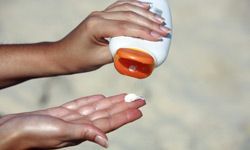 close-up of a hand being applied with sunscreen lotion