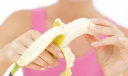 A woman peeling a banana in the foreground
