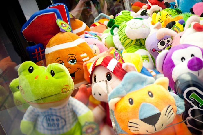A collection of stuffed animals inside a claw machine