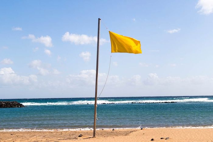 A yellow flag flying over a beach in the Canary Islands