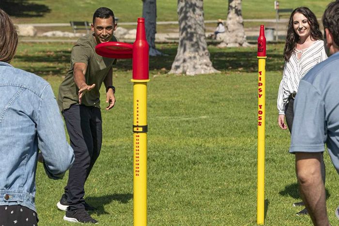 Tipsy Toss game played by 4 players on a lawn.