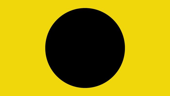A black ball displayed on a yellow beach flag